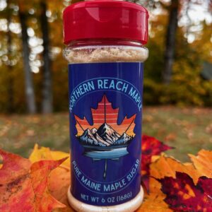 A shaker of pure maine maple sugar among the autumn leaves in Northern Maine.