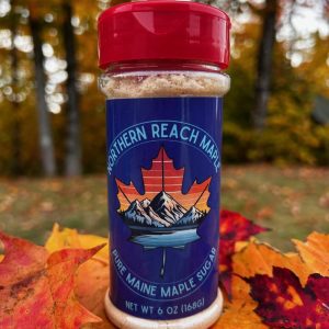 A shaker of pure maine maple sugar among the autumn leaves in Northern Maine.