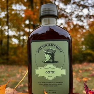 A bottle of coffee infused maple syrup among the autumn leaves in Northern Maine.