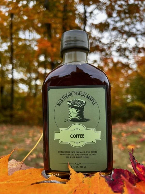 A bottle of coffee infused maple syrup among the autumn leaves in Northern Maine.