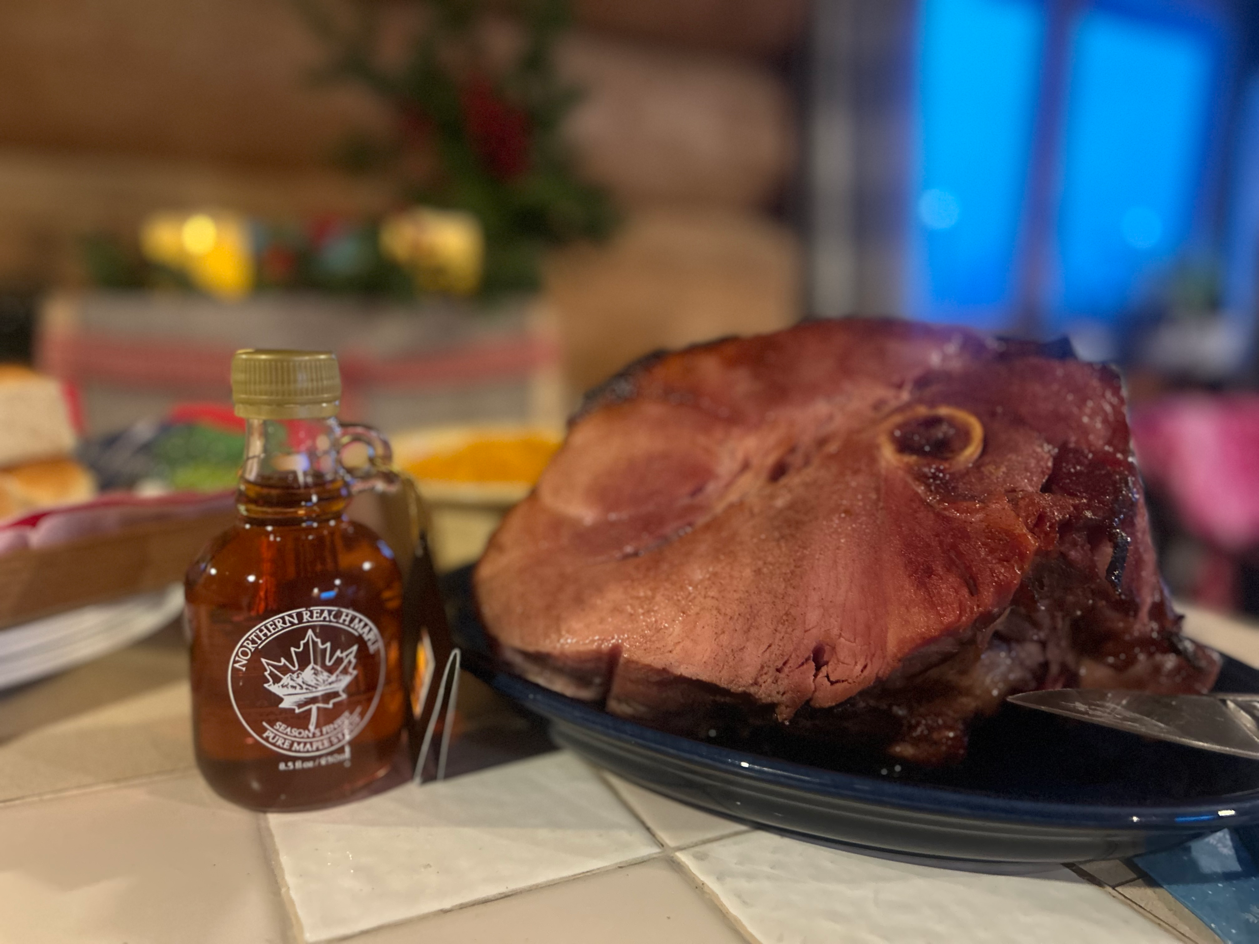 Season's Finest Maple Syrup next to a maple crusted Christmas ham