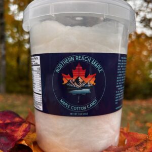 A bucket of Maine Maple Cotton Candy shown among autumn leaves in Northern Maine.