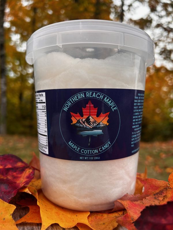 A bucket of Maine Maple Cotton Candy shown among autumn leaves in Northern Maine.