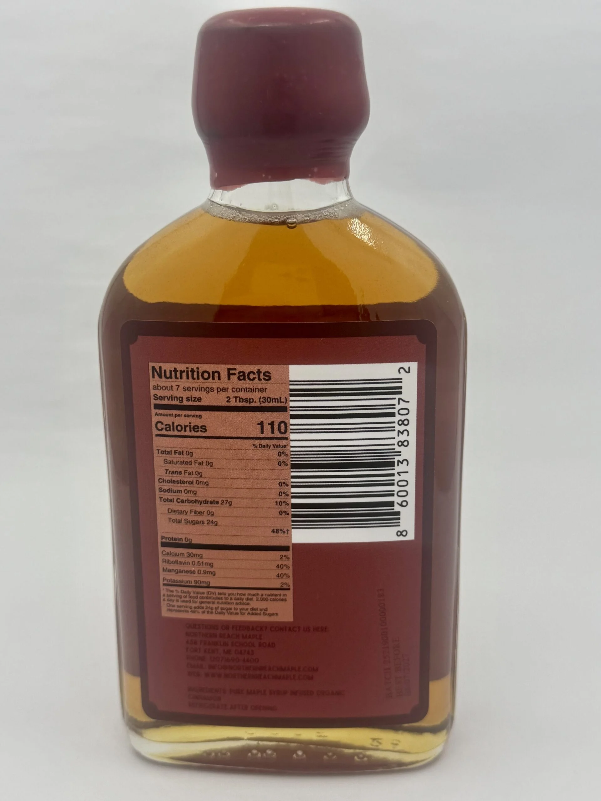 A bottle of cinnamon infused maple syrup (part of our flavored maple syrup line) showing the back nutrition facts panel.
