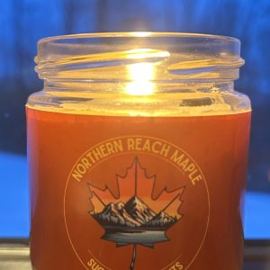 sugarhouse scents maple candle burning at night