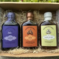 Berry, Cocoa, and Copra maple flavor trio pictured in a mailer box.