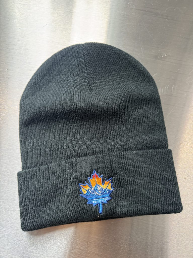 A picture of the Sugarshack beanie knit cap laying on top of stainless steel.