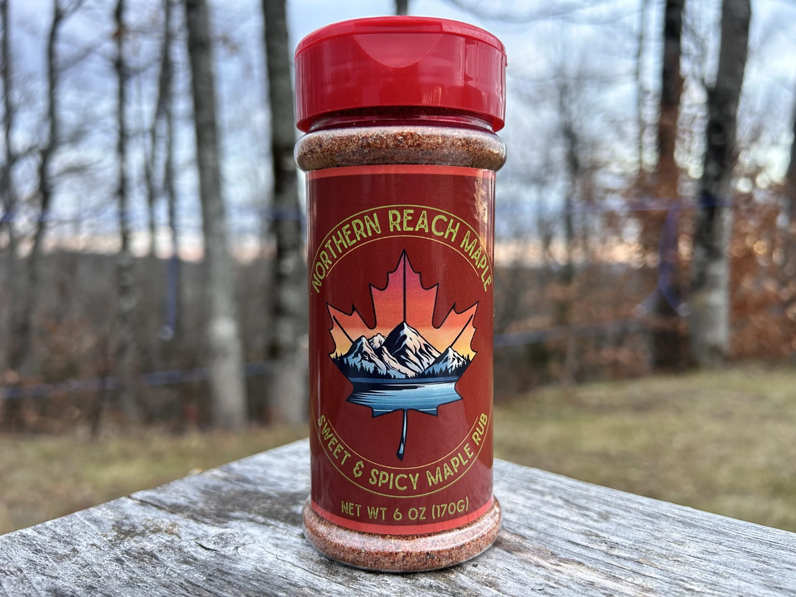 Sweet & Spicy Maple Rub, 6 oz shaker on a picnic table.